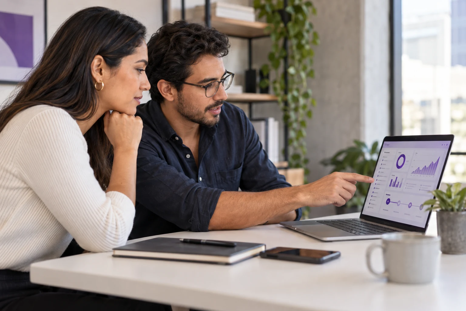 Dos profesionales analizan una solución digital en una notebook
